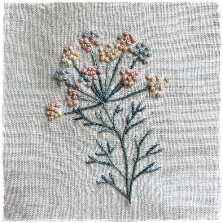 hand-stitched journal page featuring a floral design with beige, pink, and green colors on a linen background.