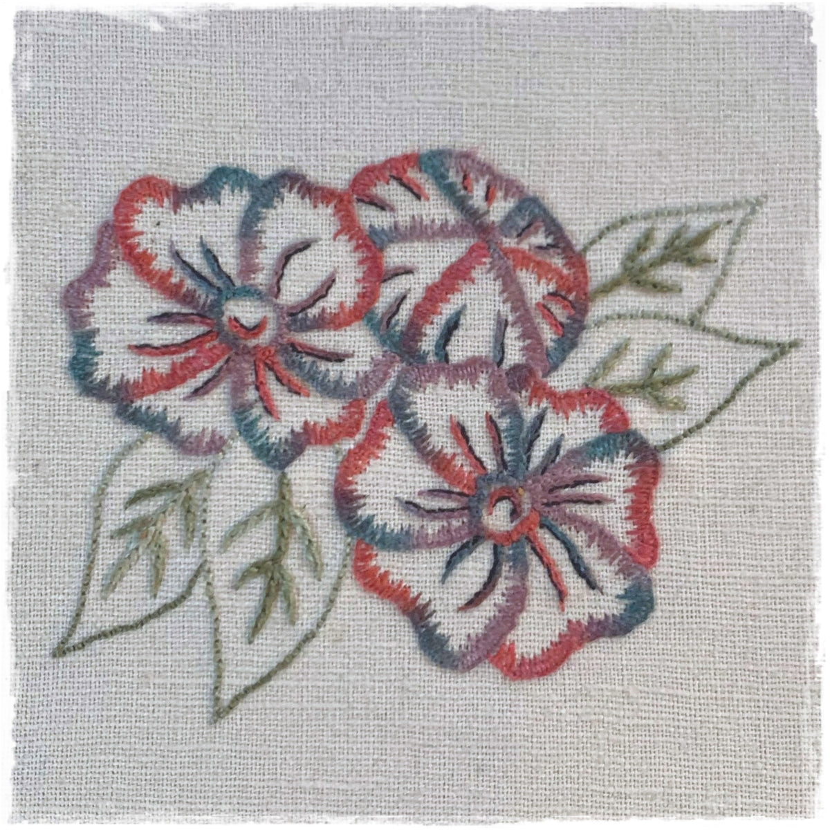 needlecraft pattern featuring a stylized floral design with multiple petals and leaves on a linen background.