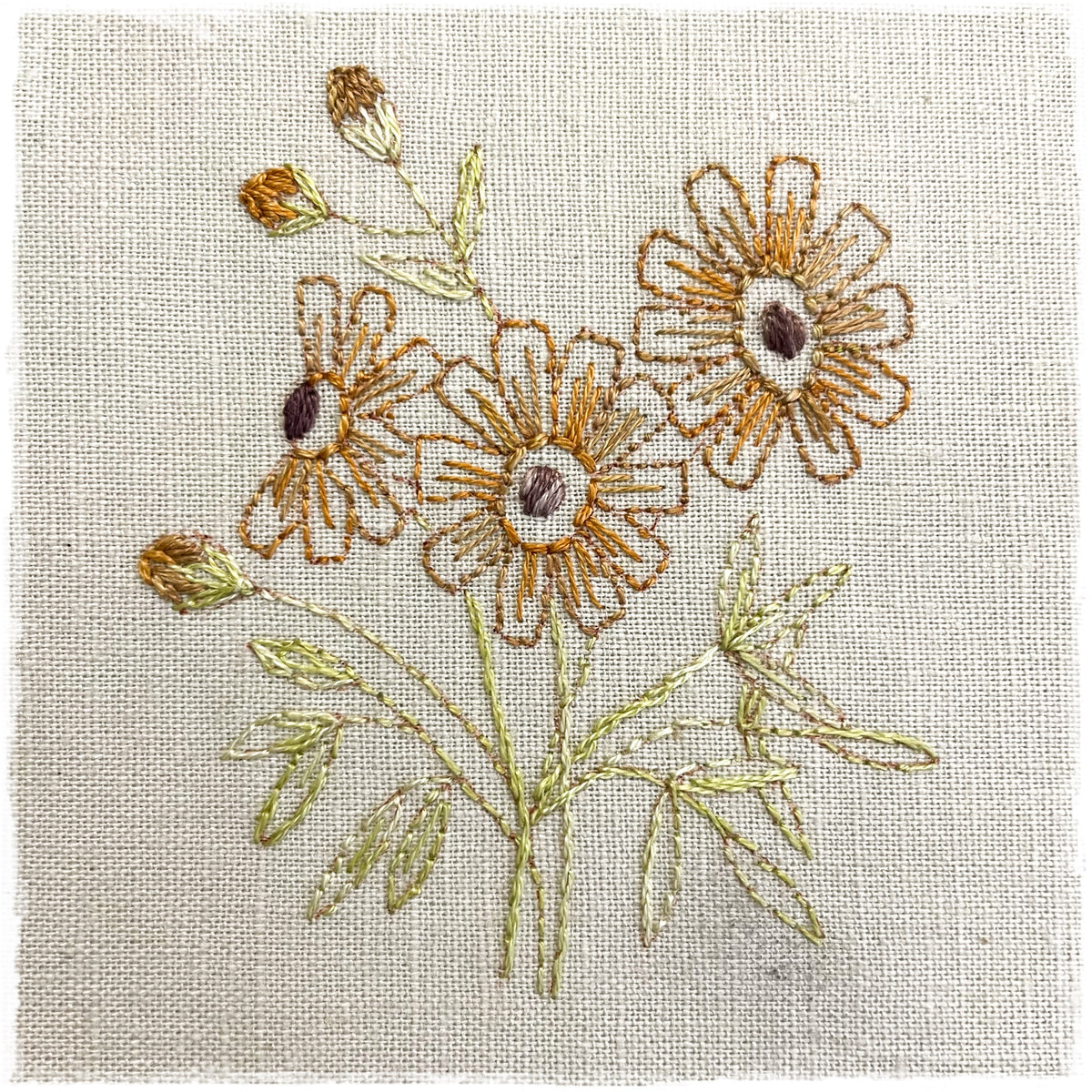 needlecraft pattern for a daisy-shaped quilt design, showing the outlined stitching on a linen background