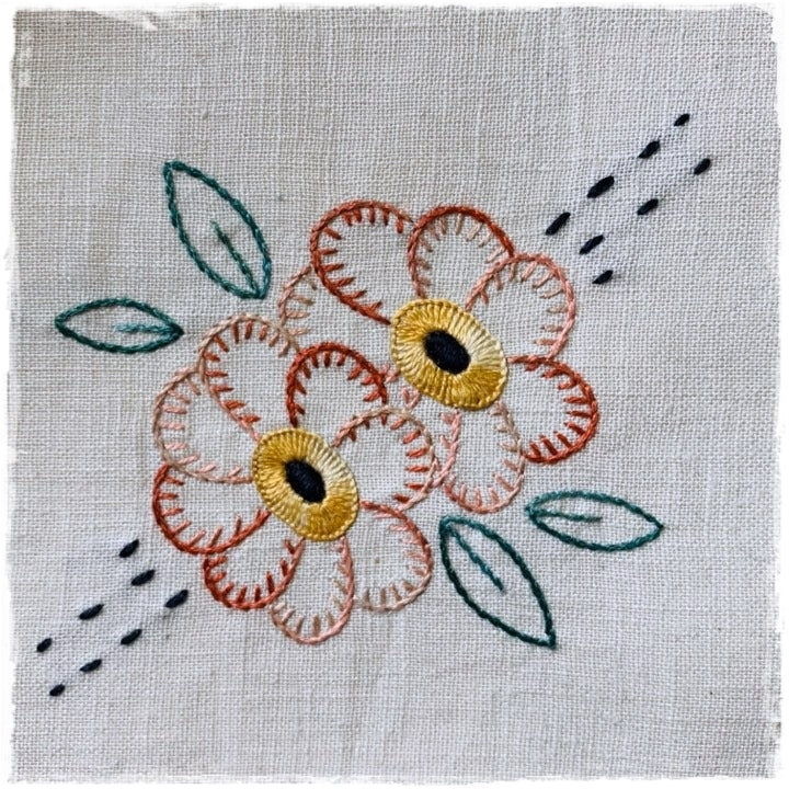 hand-stitched journal page featuring a floral design with golden centers on a white background with green leaf patterns
