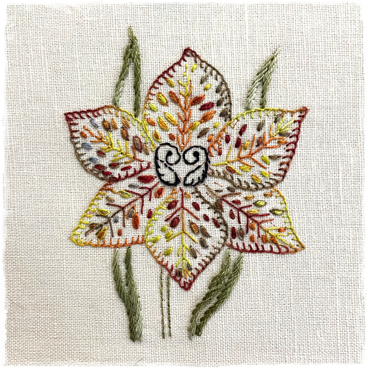 needlecraft pattern for a floral-themed journal page, with a detailed depiction of a stitched flower and leaves on a linen background.