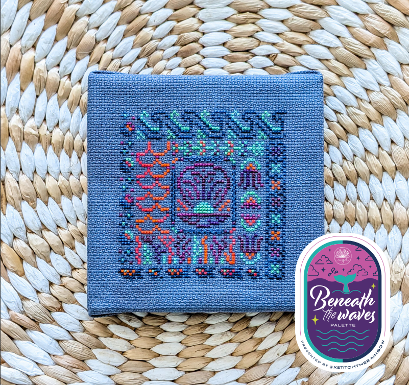A square blue cross stitched design with a colourful beneath the waves pattern.