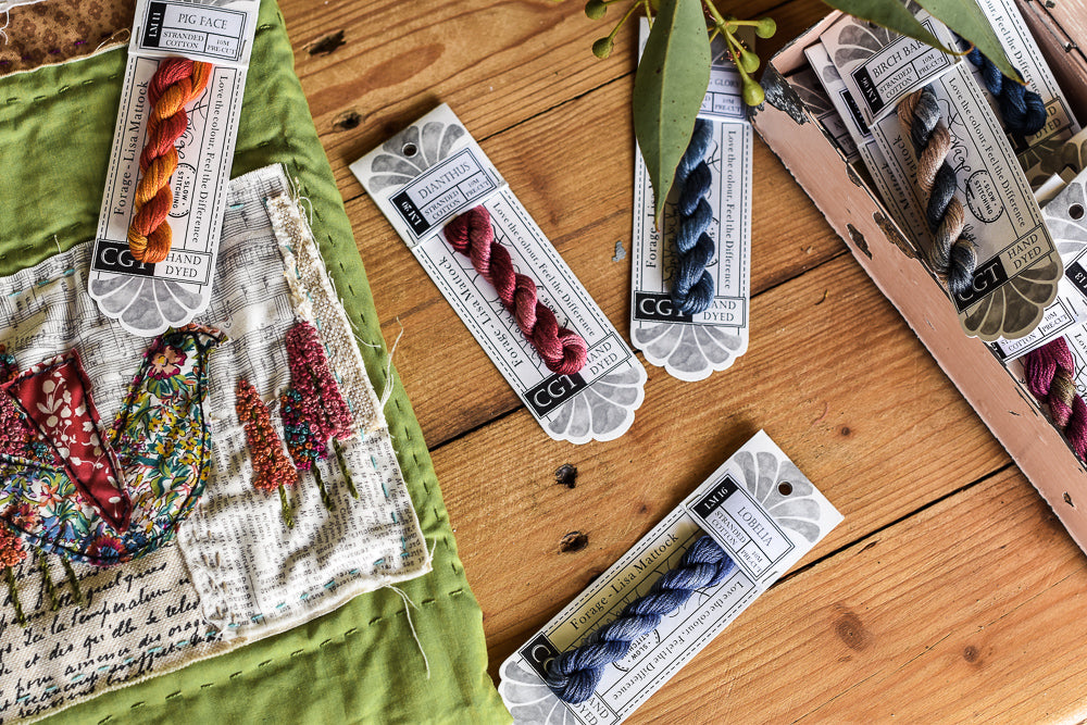 Flat lay Photo of Lisa Mattock collection of Cottage Garden threads and a bird embroidery