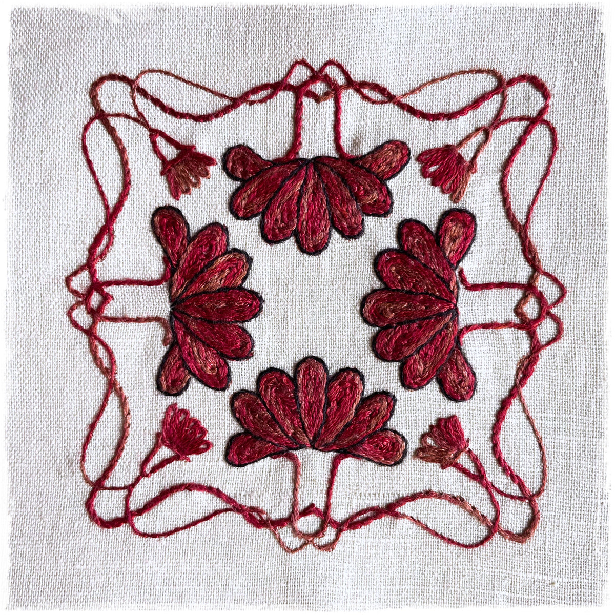 quilted journal page featuring a floral design with red and brown colors on a white background, and a visible red thread border.