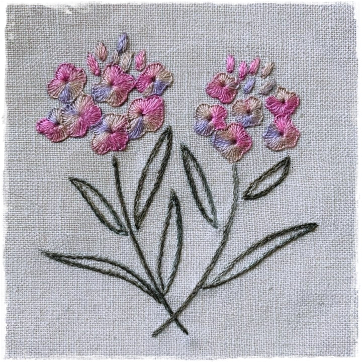 quilted fabric with a floral design, featuring pink and purple flowers and green leaves on a beige background