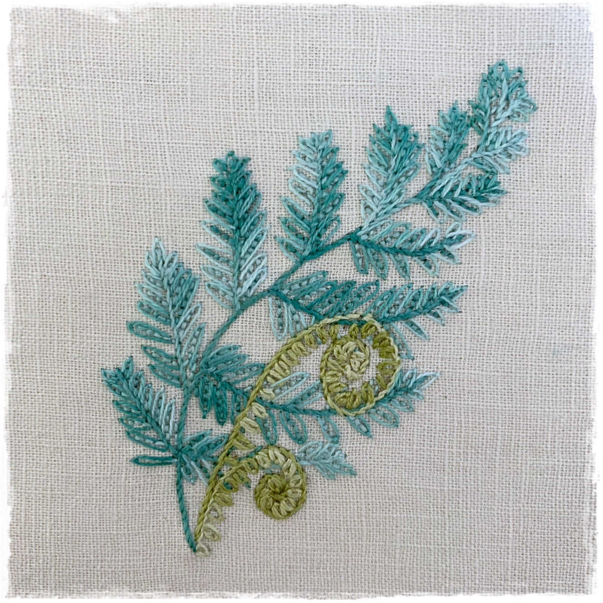 journal page with a floral design and color instructions, stitched on a linen background.