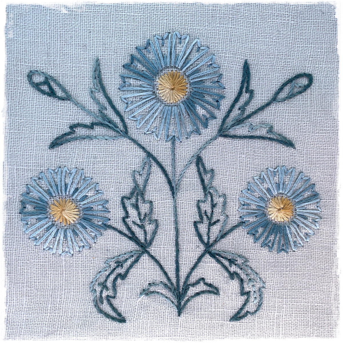 needlecraft pattern featuring a floral design with blue and green colors on a white background.