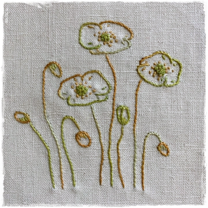 needlecraft pattern for a quilt, featuring a stylized floral design with green, white, and orange colors on a beige background