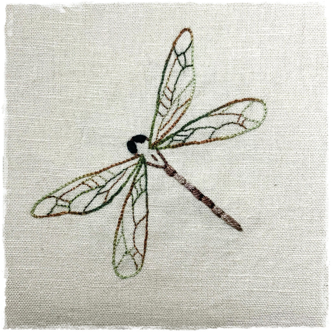 needlecraft canvas with a stitched design of a dragonfly