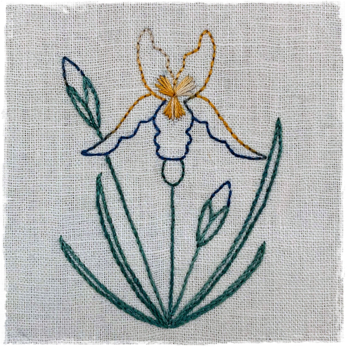 needlecraft pattern for a field journal quilt, featuring a design of a flower with green and blue threads on a beige background