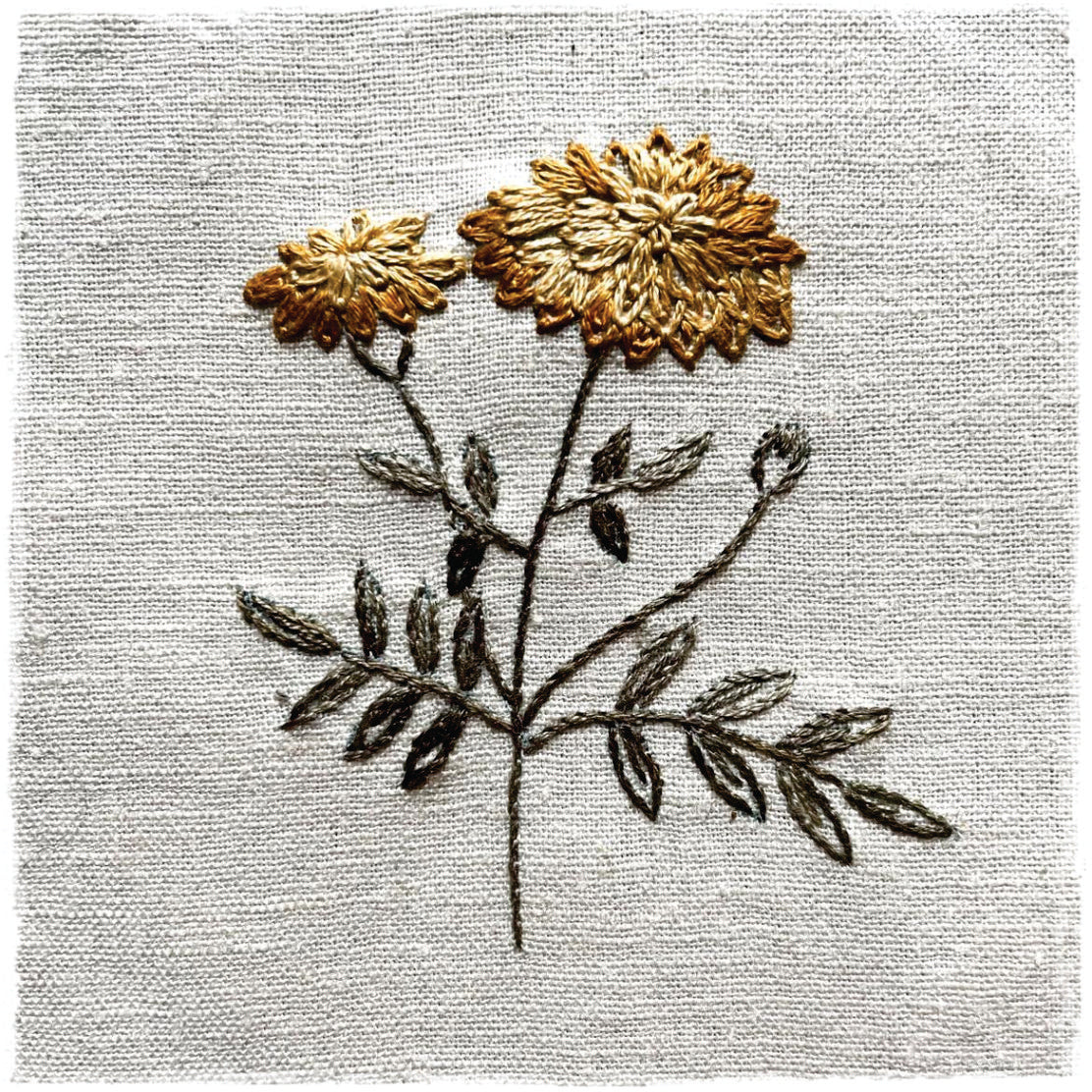 needlecraft canvas with a floral design, predominantly in gold and green colors on a beige background