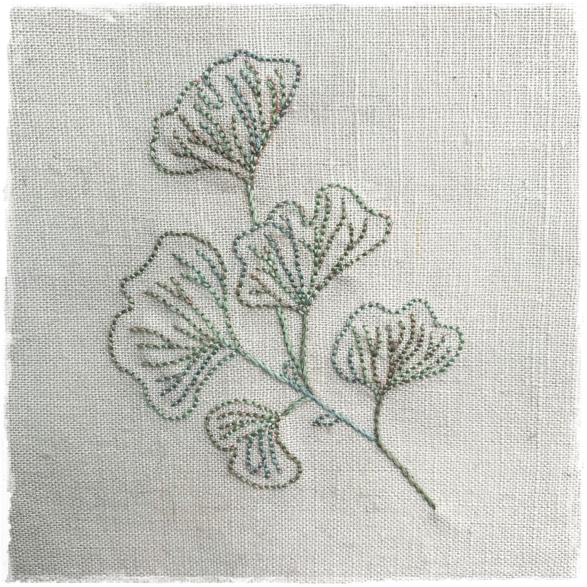 linen fabric with a detailed floral embroidery design stitched on it.