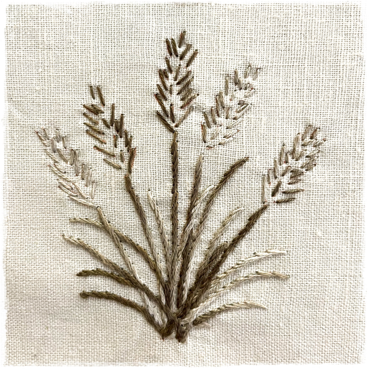 embroidered design featuring a plant on a linen background, likely a digitized version of a quilt pattern.
