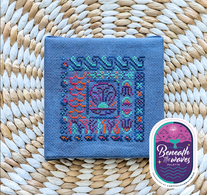 A square blue cross stitched design with a colourful beneath the waves pattern.