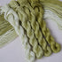 Four twisted skeins of embroidery thread in shades of palest green to olive.