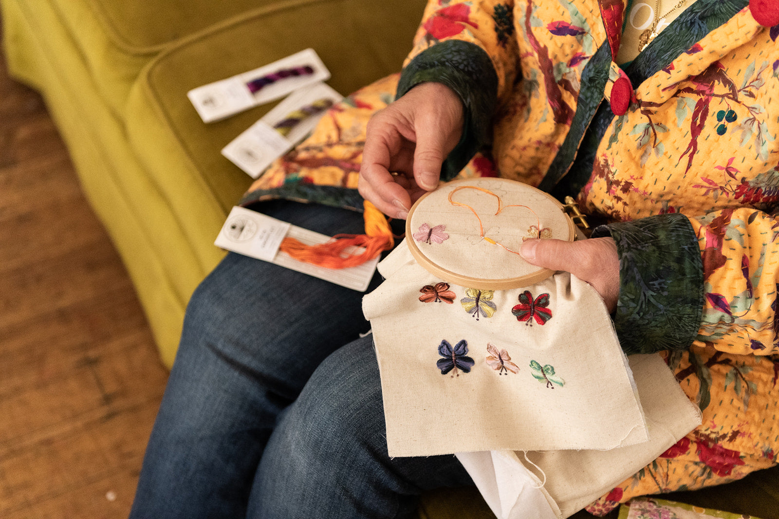 Veronique Diligent completing embroidery of butterflies